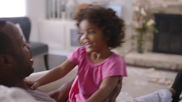 Father bouncing daughter on lap