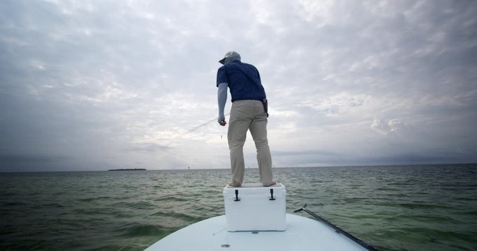 Caucasian Fisherman Fly Fishing On Skiff Boat