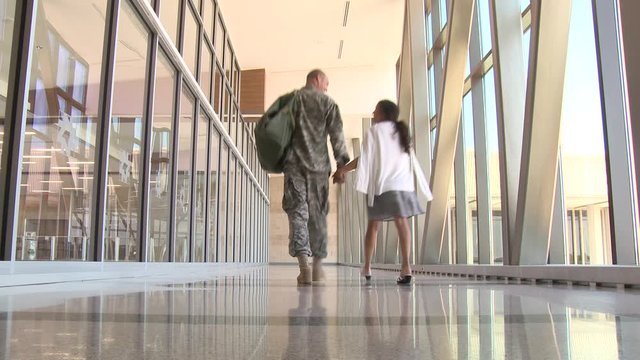 Soldier and girlfriend walking in airport
