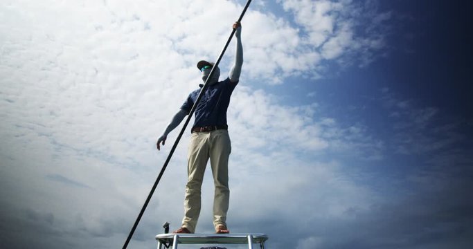 Caucasian fishing guide poling a skiff boat
