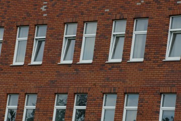 row of white windows on a brown brick wall of a building
