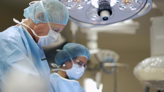 Surgeon and nurse in operating room