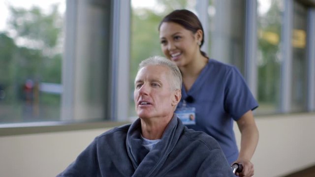 Nurse pushing patient in wheelchair in hospital corridor