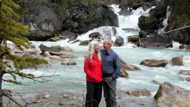 Caucasian couple posing at waterfall, Lake Louise, Alberta, Canada