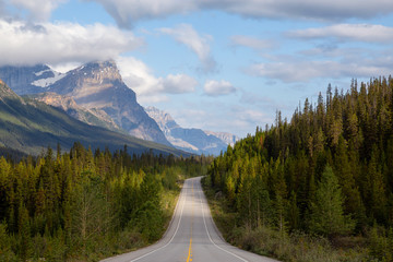 Scenic road in the Canadian Rockies during a vibrant sunny and cloudy summer morning. Taken in...