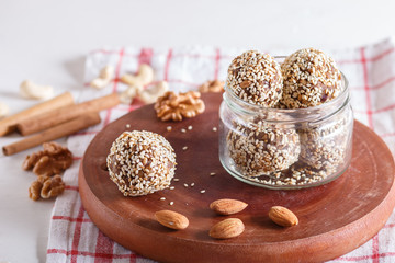 Energy balls cakes with almonds, sesame, cashew, walnuts, dates and germinated wheat in glass jar,...
