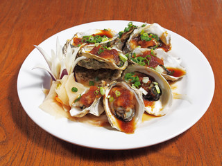 Opened oysters with sauce on the plateCAMERA
