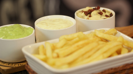 Crispy french fries on a tray with 3 bowls of sauce