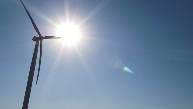 Silhouette of wind turbine on sunny day