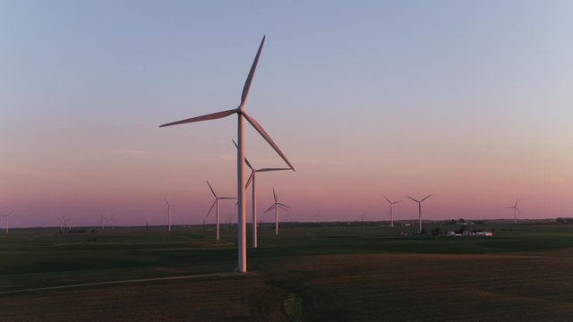 Zoom in on wind farm at sunset