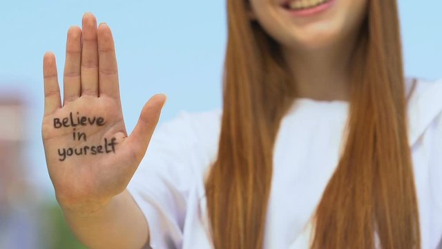 Believe in yourself written on female palm, youth motivation, encouragement