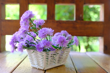 bouquet of flowers in a basket on wooden table