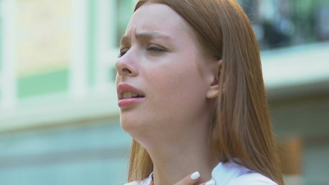 Sick woman coughing outdoors, spring allergy symptom, health care, treatment