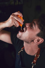 Young chef in kitchen squeeze orange and lime for juice. Food concept.