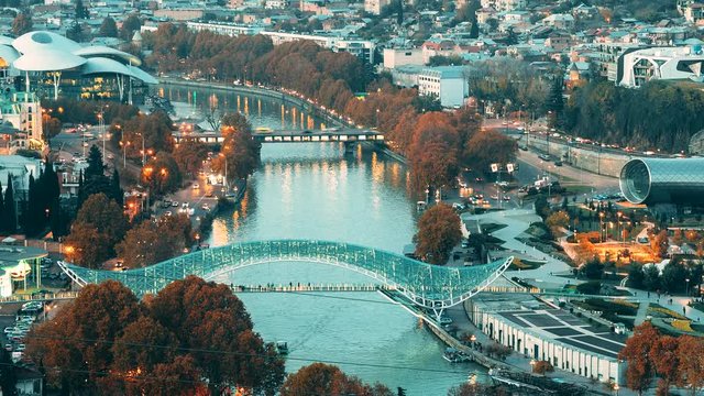 Tbilisi, Georgia. Top View Of Famous Landmarks In Night Illuminations. Georgian Capital Skyline Cityscape. City During Sunset And Night Illuminations. Day To Night Transition
