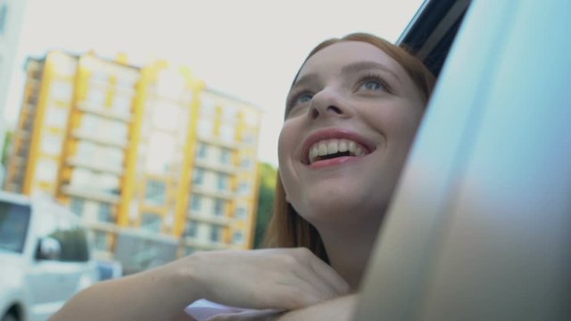 Joyful female teenager sitting taxi looking around city, travel joy, adventure