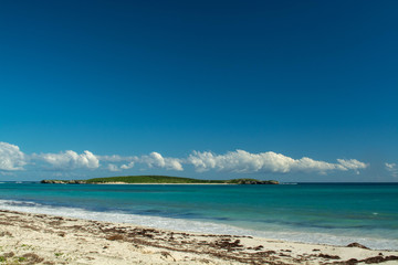 Island offshore from mainland with sun shining