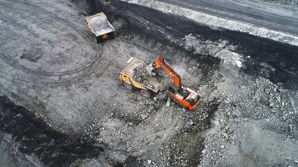 Coal mining in a quarry. A hydraulic excavator loads a dump truck.