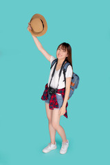 Beautiful portrait young asian woman smiling and holding hat and camera travel summer trip in vacation isolated on blue background, tourist asia girl cheerful journey with hobby in holiday concept.