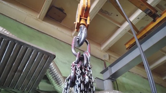 Chain slings are suspended on a powerful crane suspension hook.