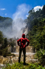 Men standing on Thi Lo Su Waterfall in Umphang Wildlife Sanctuary, Umphang Tak, Thailand.