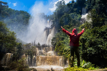 Men standing on Thi Lo Su Waterfall in Umphang Wildlife Sanctuary, Umphang Tak, Thailand.