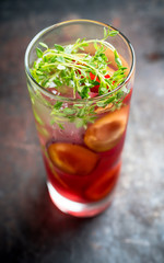 Cocktail with plums and thyme on the rustic background. Selective focus. Shallow depth of field.
