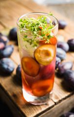 Cocktail with plums and thyme on the rustic background. Selective focus. Shallow depth of field.