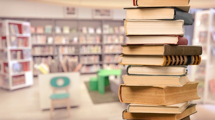 Collection of old books vertical stack on beige background