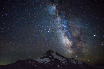 Naklejka na ściany i meble Milky Way, galaxy, and stars loom over volcanic mountain.