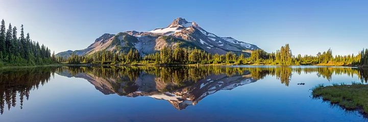 Abwaschbare Fototapete Berge Vulkanischer Berg im Morgenlicht spiegelt sich im ruhigen Wasser des Sees.