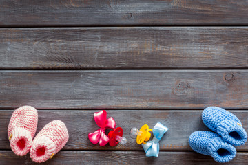 Blue and pink knitted footwear for kids, dummy on wooden background top view space for text
