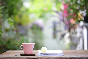 Pastel pink cup with rose flower and books at outdoor 