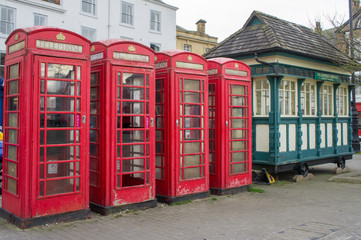 Four red telephone kiosks in a row