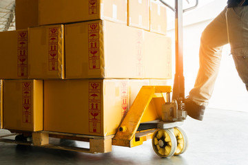 warehouse worker working with hand pallet truck and goods pallet shipment unloading at distribution warehouse, business industry delivery transportation, © Siwakorn1933