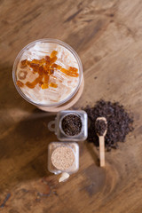 A glass of ice tea with tea powder and brown sugar, tea powder in bottle and spoon, Earl gray milk tea with jelly.