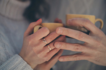 male, female hands and cups close-up. Break for lunch or coffee, tea, couple in love. Valentine's day