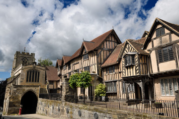 Fototapeta na wymiar Crooked medieval tudor houses of Lord Leycester Hospital at 12th Century Chapel of St James over West Gate on High Street Warwick England