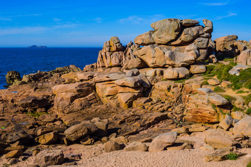 Fototapeta na wymiar Seascape with huge pink granite boulders near Plumanach. The coast of pink granite is a unique place in Brittany. France