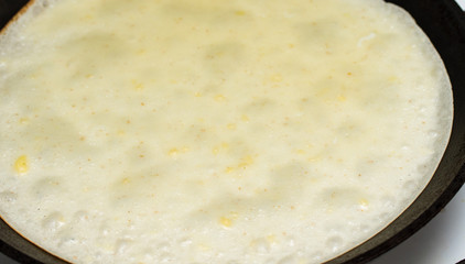 Food. Pan fried pancake with butter, black frying pan, yellow butter pancake, background, fragment