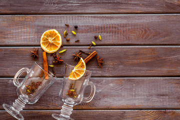 New Year beverage. Ingredients for mulled wine in glasses on dark wooden background top view copy...