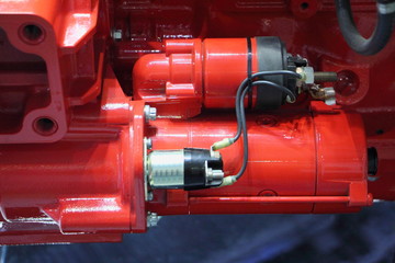 Red electric stater unit on new truck motor engine close up
