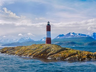 View of the picturesque Les Eclaireurs (the scouts) Lighthouse on a small island in the Beagle Channel in Tierra del Fuego, Argentina, with the snowcapped Andes mountains in the background.