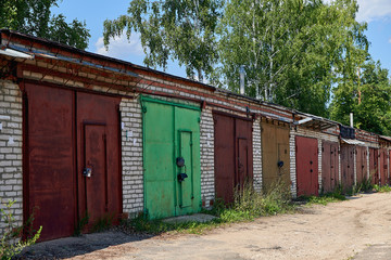Old brick garages with metal gates. Garage cooperative for car storage.