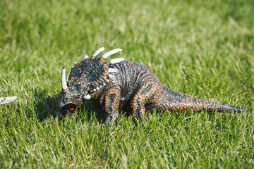 Dinosaur, prehistoric lizard on the green grass. Children's toy. Extinct reptile.