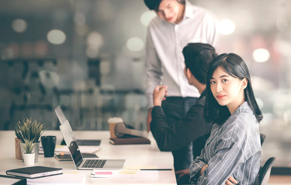 Portrait of young female designer smiling and looking at camera while working at studio.
