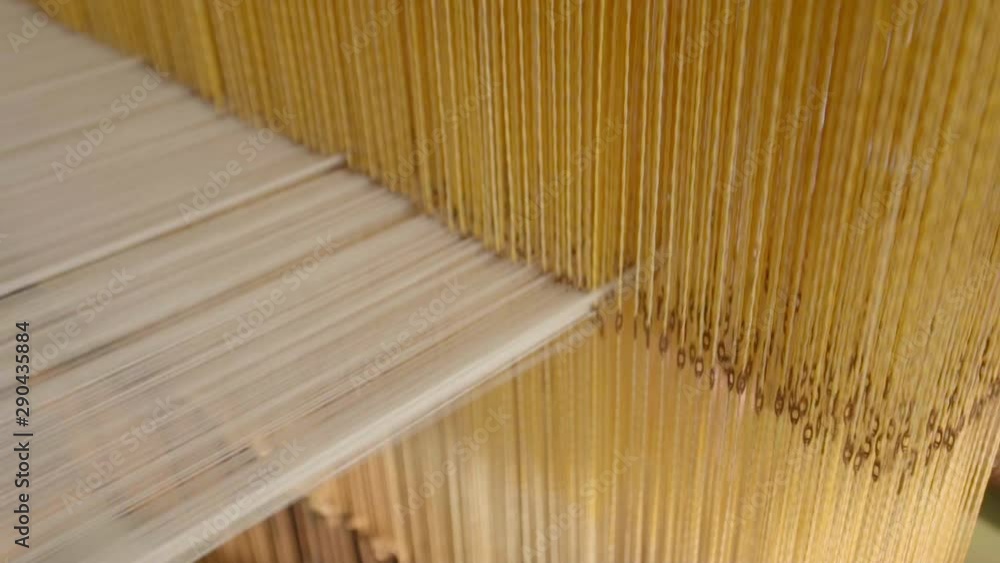 Poster close up shot of a manual loom powered for textile production as part of a weaving process