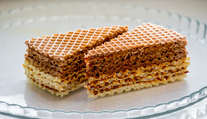 Delicious sweet wafer cookies on a glass plate_