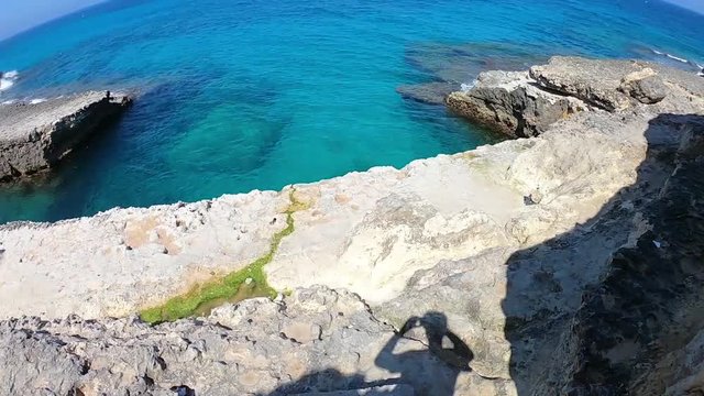 HL walking on rocks ending up in cave and natural pool of sea water in Salento, Puglia, Italy