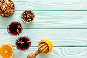 Romantic New Year with two glasses of mulled wine on green wooden background top view frame space...